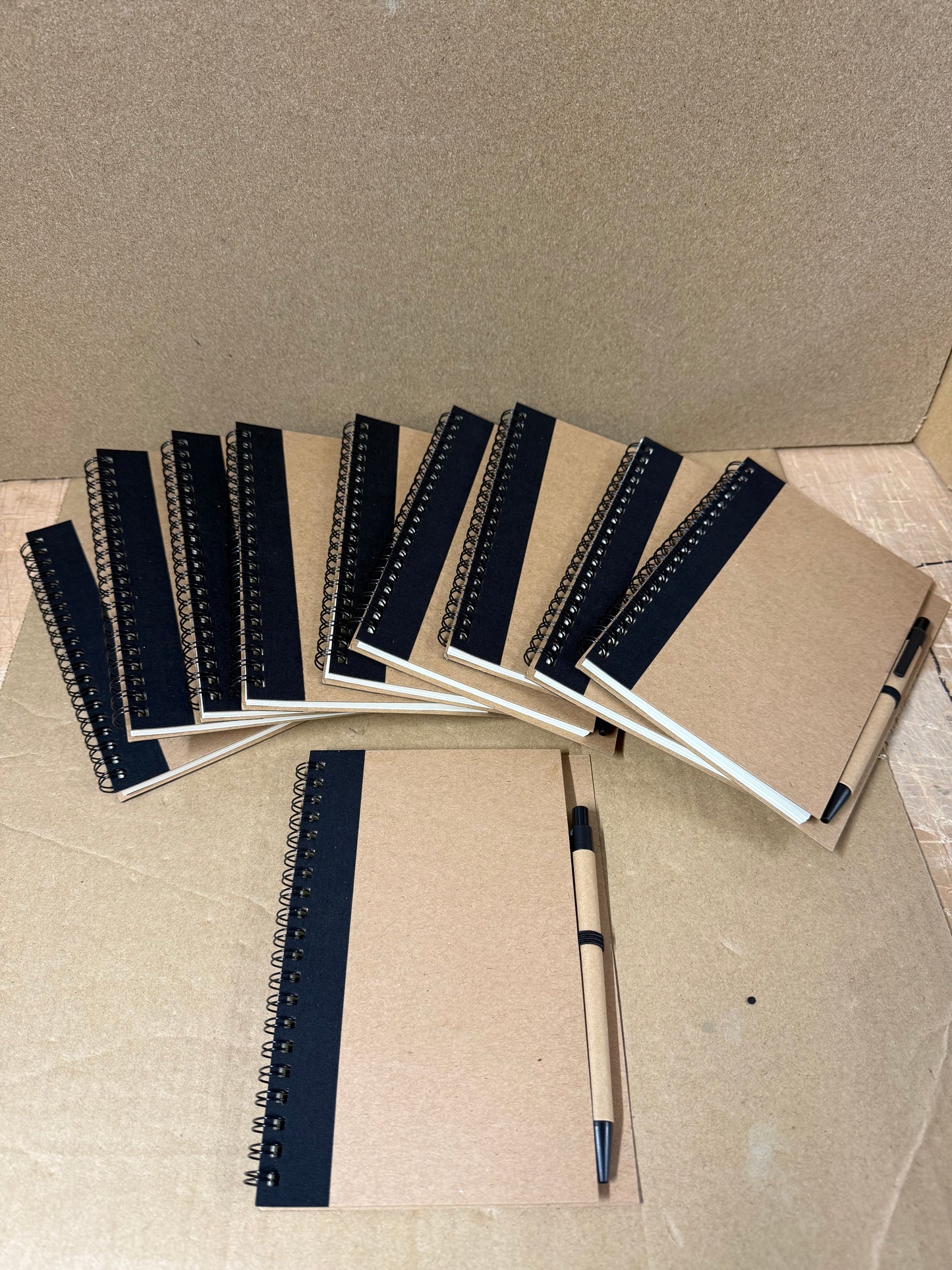 10x coloured spiral notebooks with pens